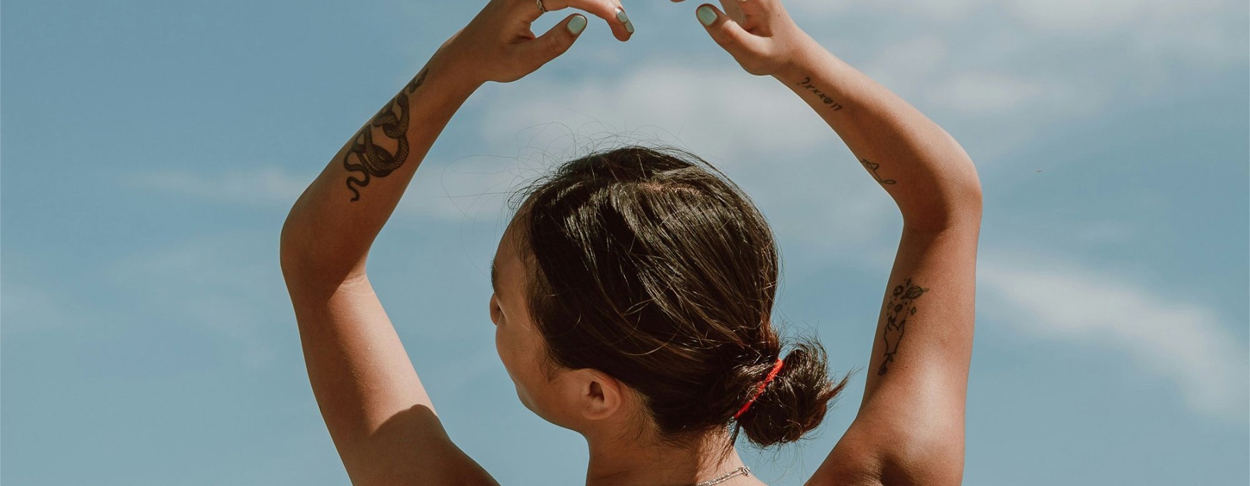 a person with the hands in the air in front of the ocean