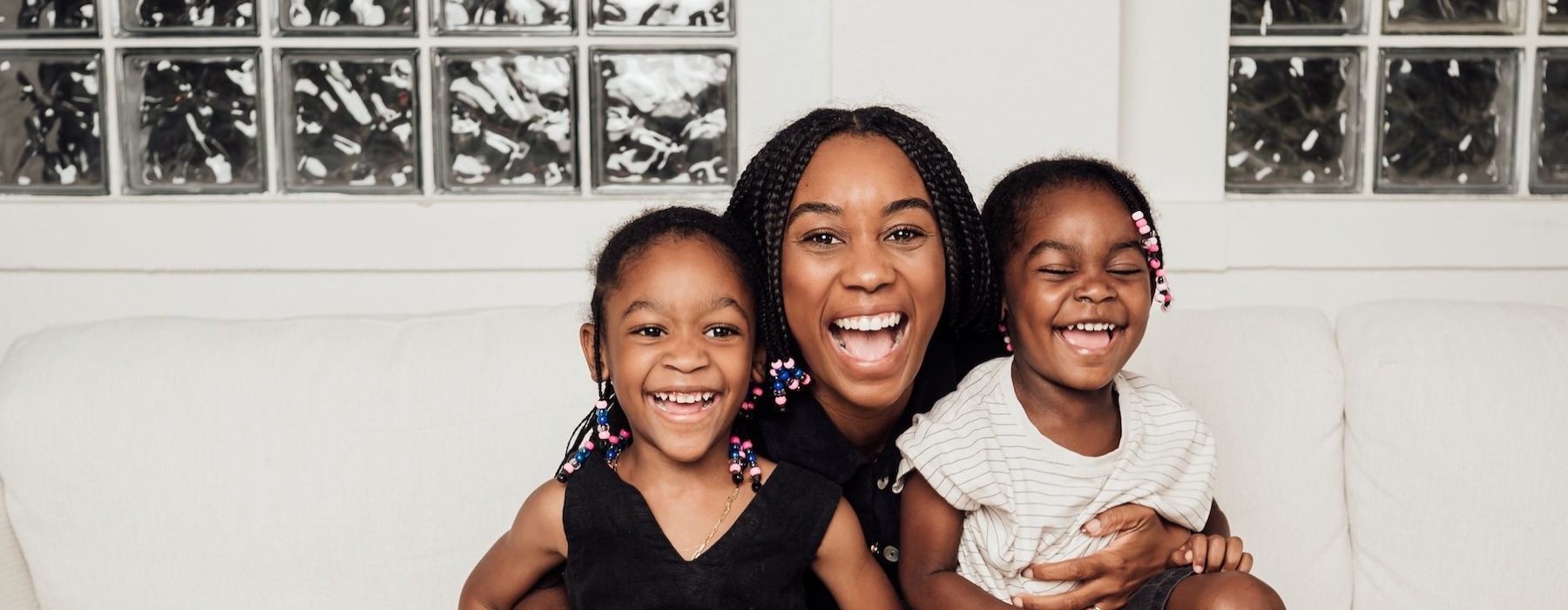 a woman sitting on a couch with two kids
